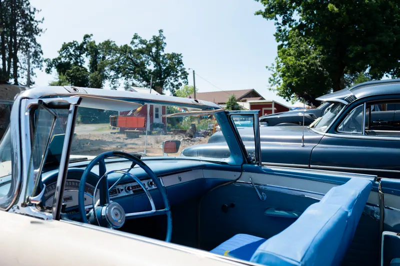 Interior of a convertible with the top down, looking across the steering wheel and dash to the chrome trim