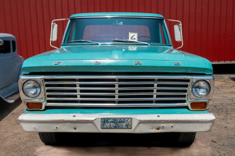 Head-on view of the turquoise pickup, grille and dual headlights centred and symmetrical